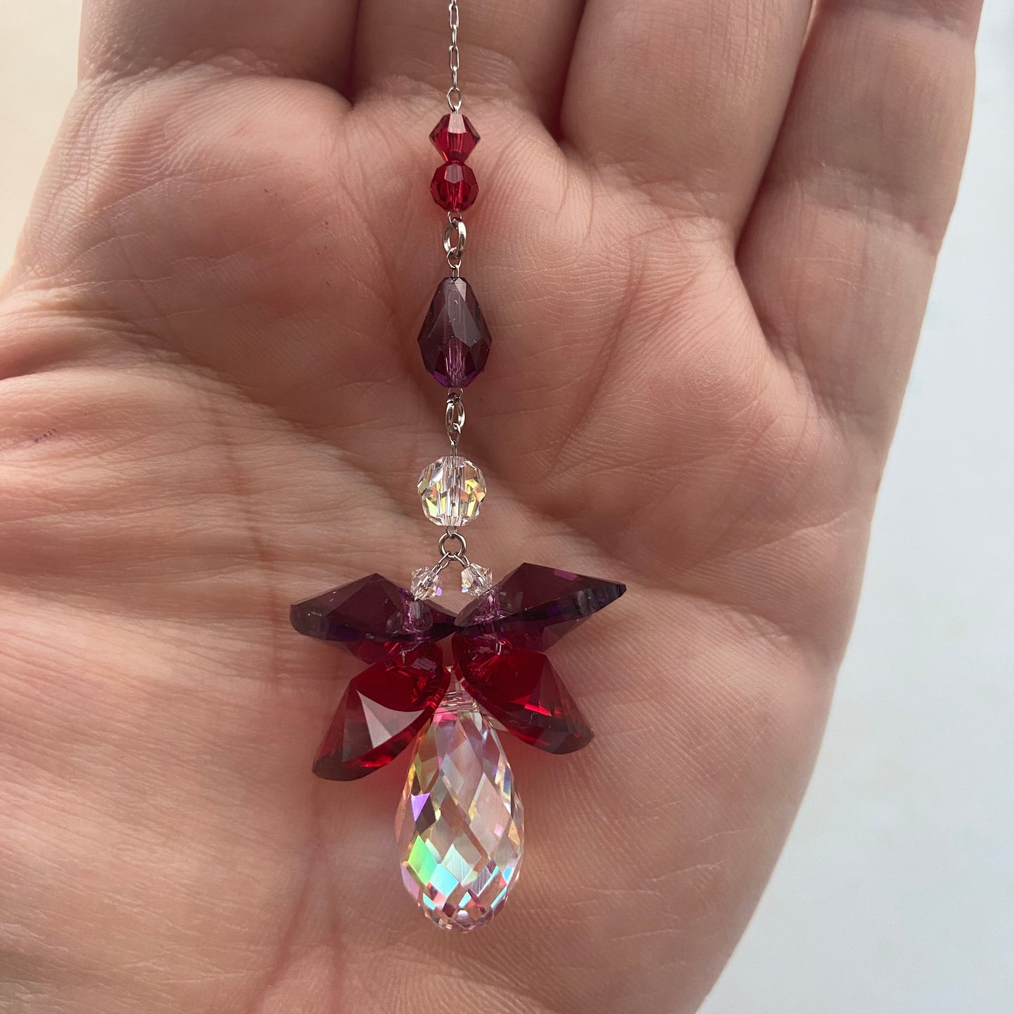 Aurora krystalengel med facetterede Swarovski® prismer, der reflekterer solens lys.