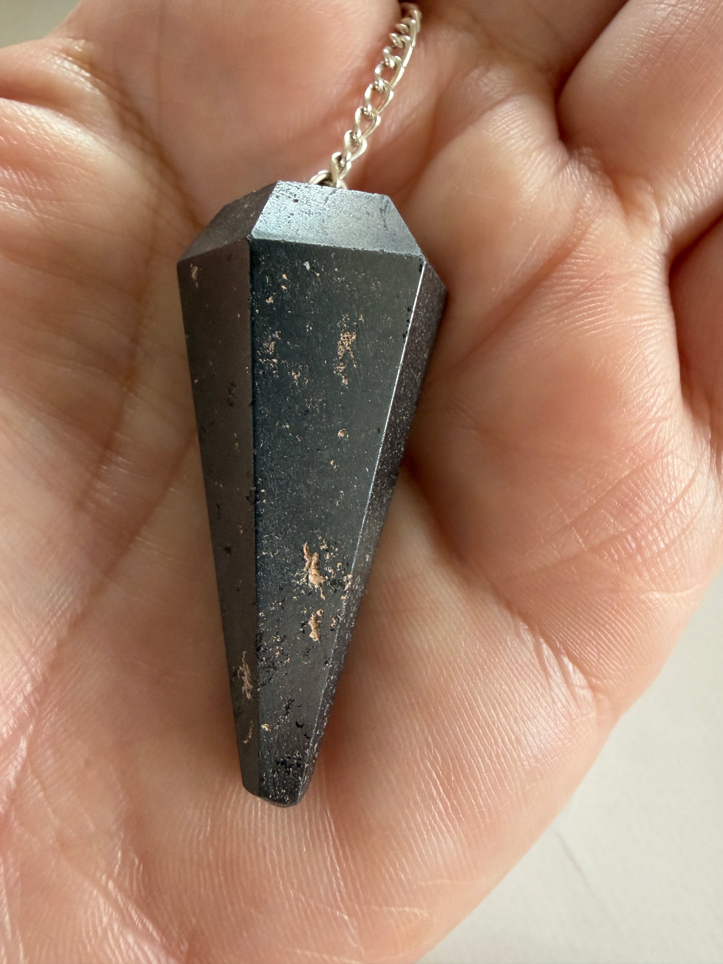 Hæmatit pendul kendt for stærk grounding og stabiliserende energi.