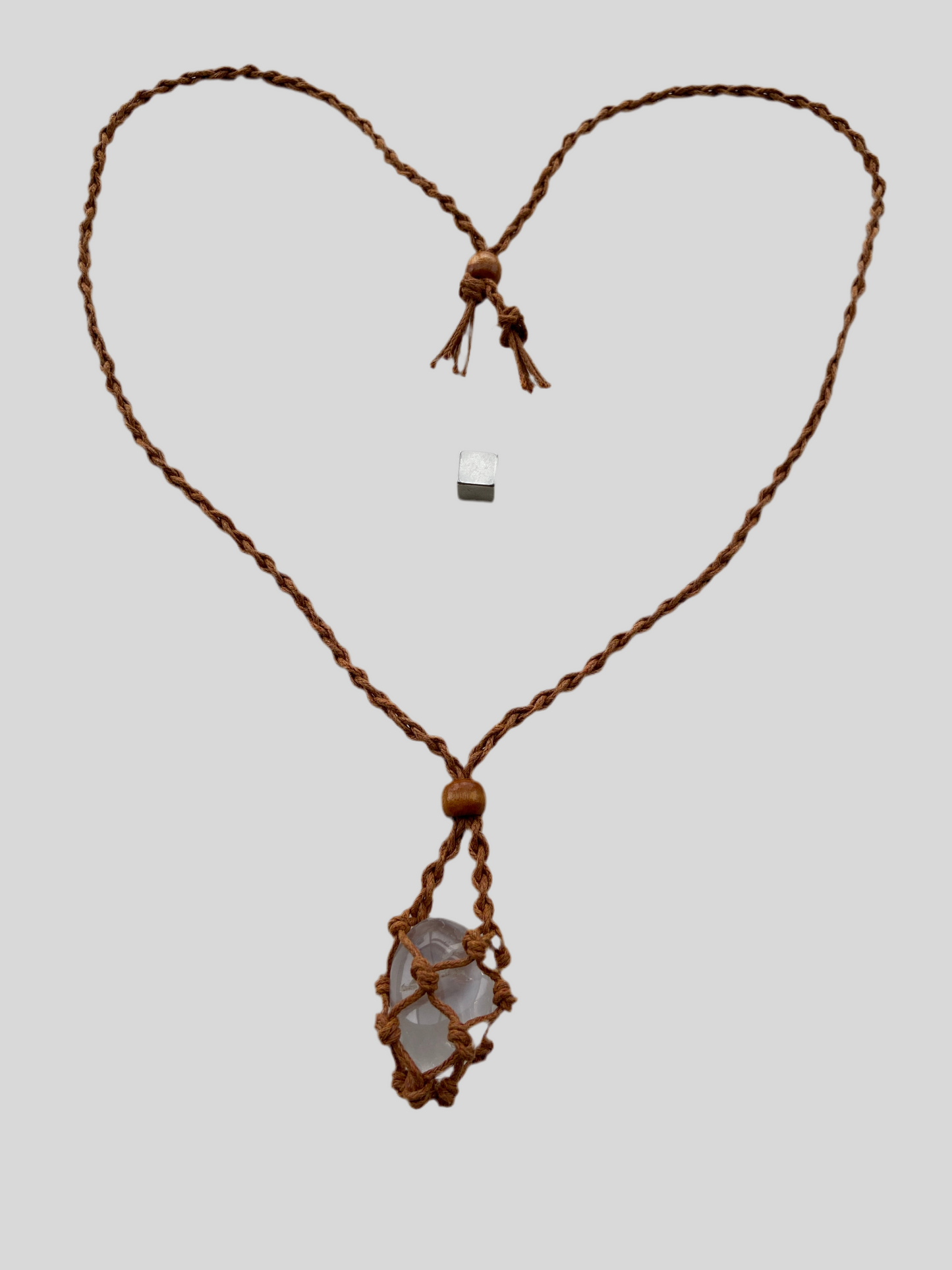 Krystalvedhæng med brunt bur i hør.