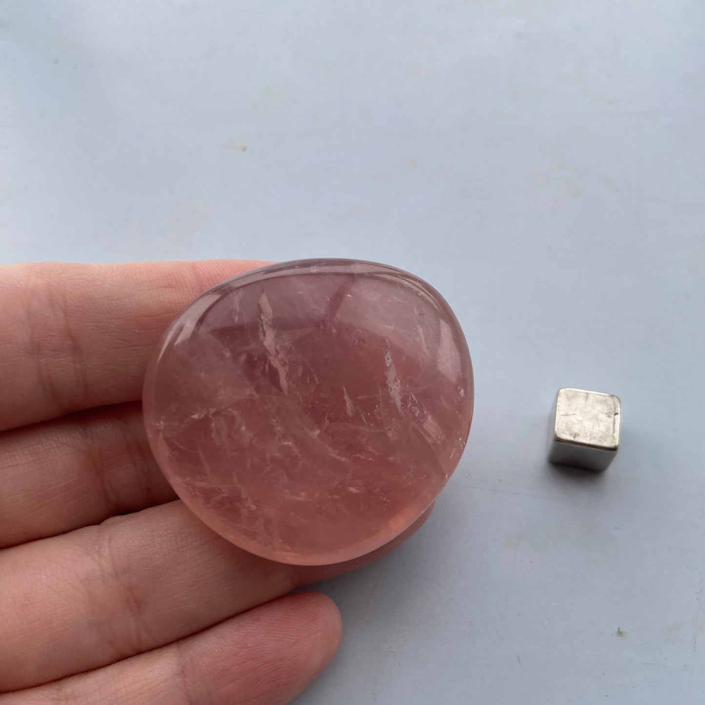 Flad rosakvarts palmstone fyldt med hjerteenergi.
