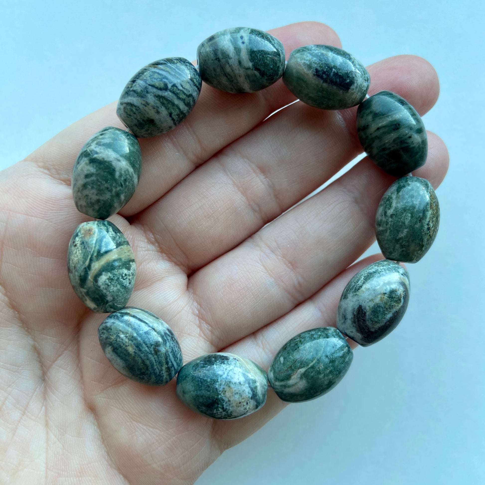 Armbånd i mørk agat træ med naturlige mønstre.