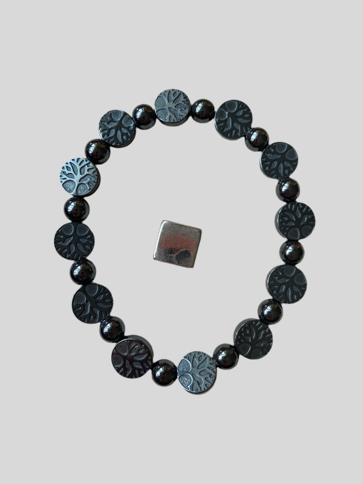 Armbånd i hæmatit med Livets Træ symbol på begge sider.