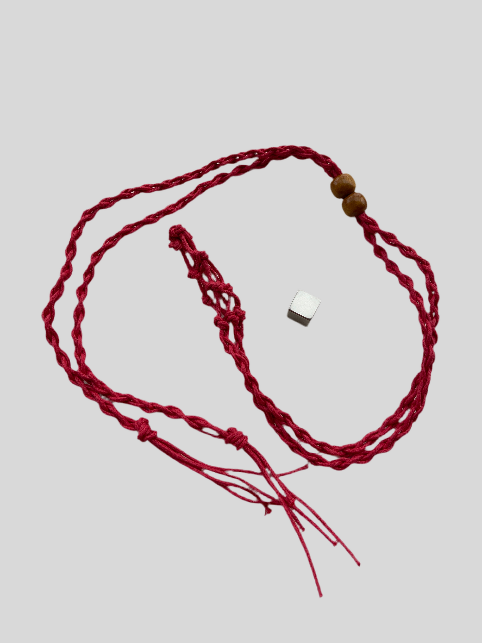 Rødt bur til krystaller i hør til personligt krystalvedhæng.