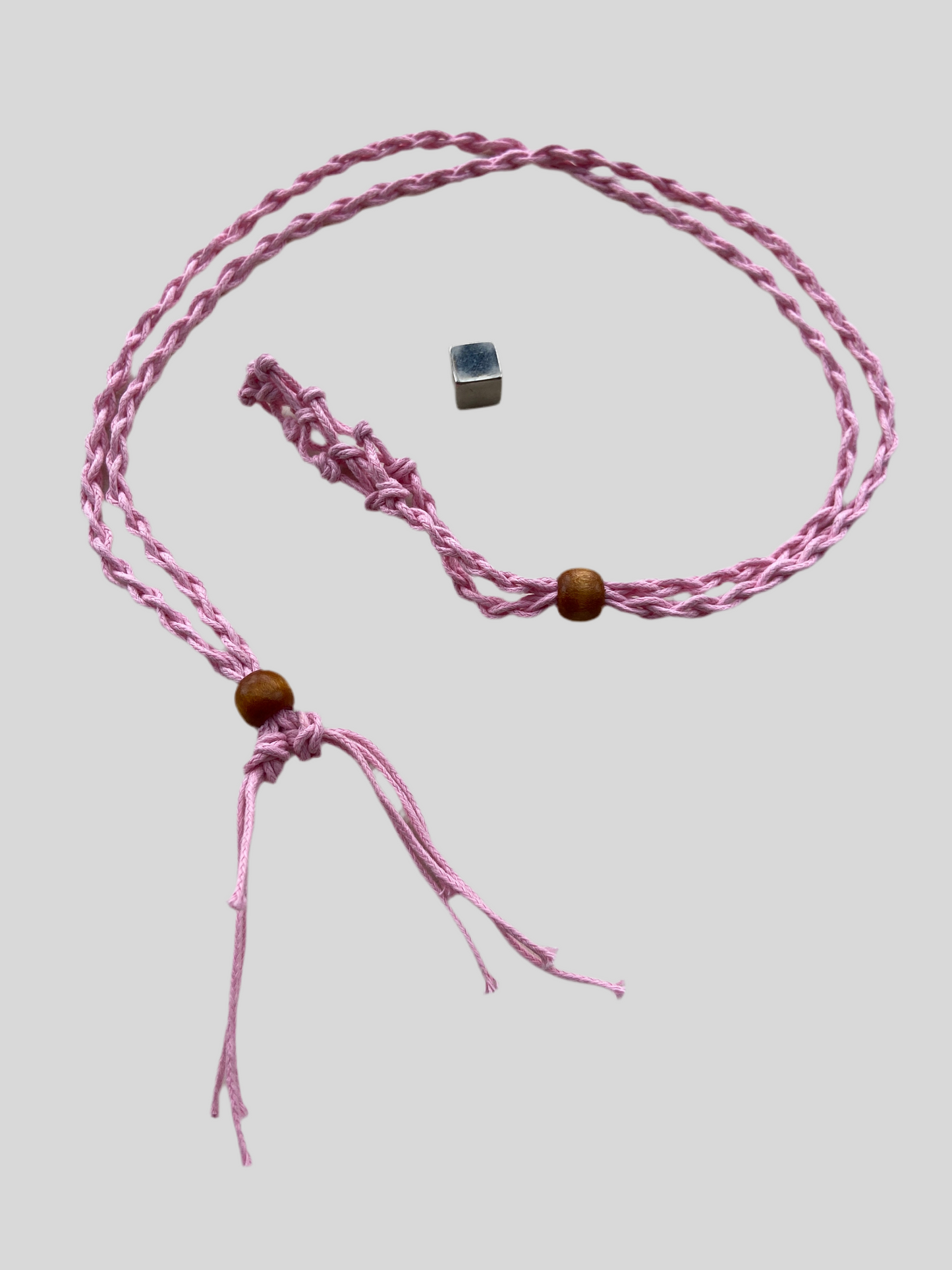 Lyserød krystalholder som fleksibelt spirituelt smykke.