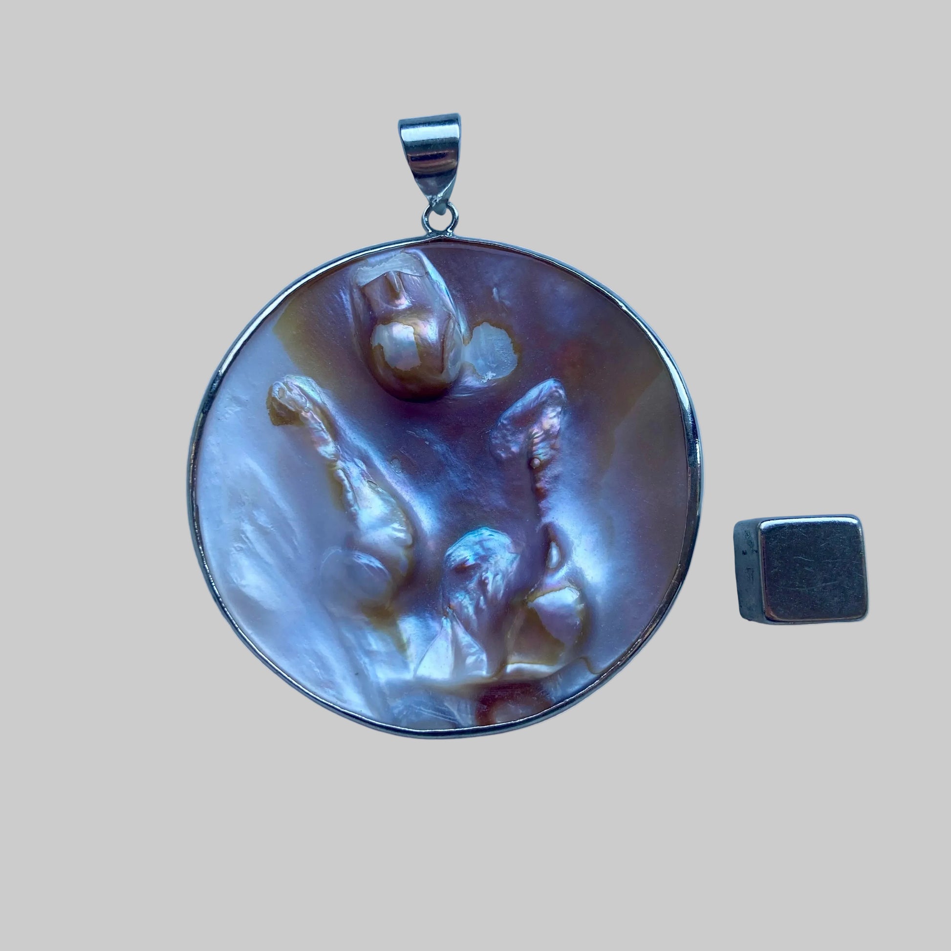 Perlemor vedhæng der støtter beskyttelse og tryghed.